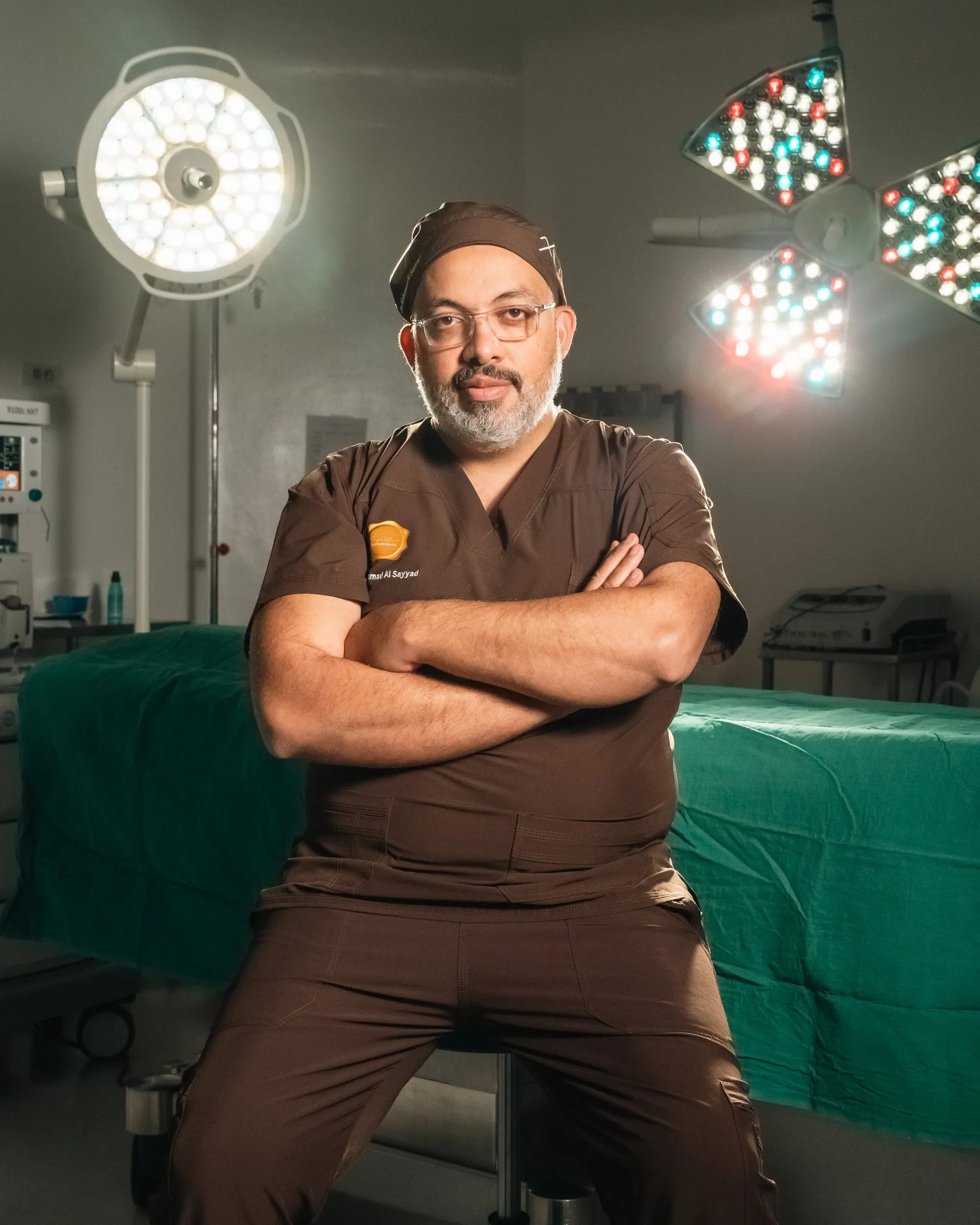 A surgeon with arms crossed in the operating room under the lamps